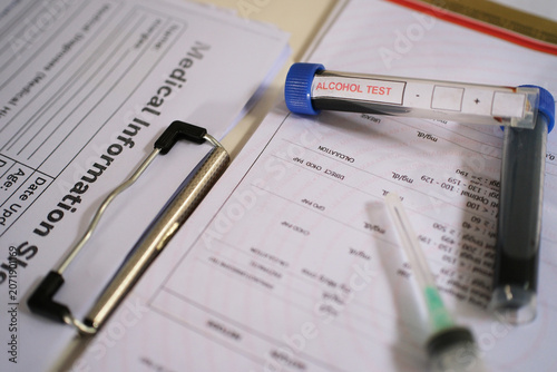 Foto Blood sample test for blood alcohol content above laboratory documents