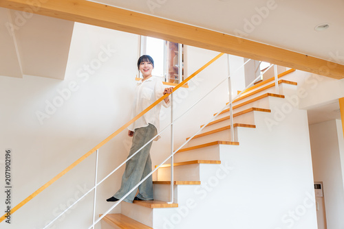 手すりがある階段を降りる若い女性
