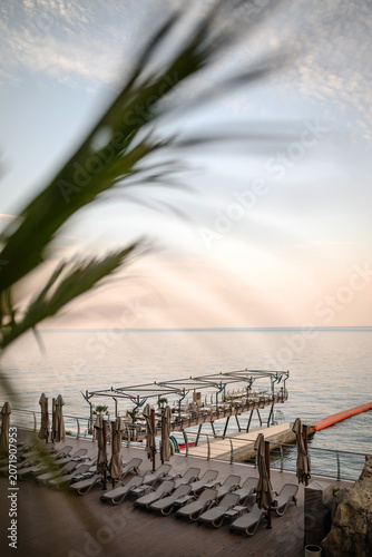 Cuadro en lienzo Sea terrace with sun loungers at sunset