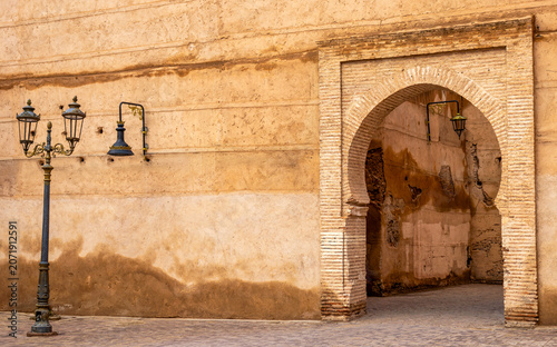 Traditional Moorish Archway and Vintage Streetlamp on Clay Wall in Old Medina of Marrakech, Morocco