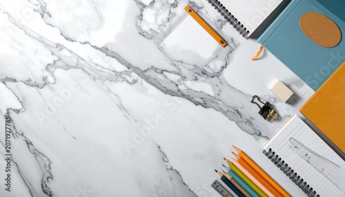 Desktop supplies on white marble background top view.