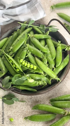 Fresh green peas rotating in a bowl