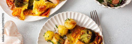 Tablou pe pânză Baked potatoes are served with salmon, broccoli, and tomatoes on a plate