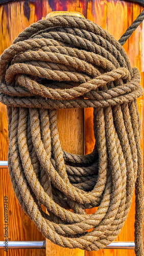 Rope tied on a wooden post in a marine setting during daylight hours