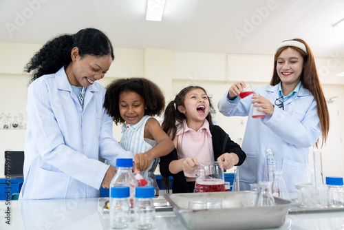Very two female teachers and two young girls conducting a science experiment in a laboratory