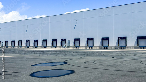 Large building exterior with loading docks and clear blue sky