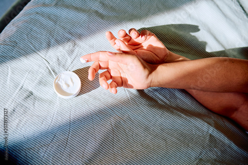 Bilde på lerret Person hydrating hands with a topical moisturizer cream, practicing self-care an