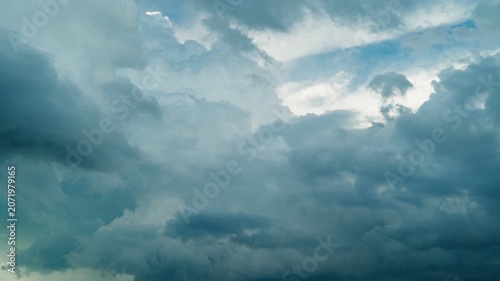 Gloomy storm clouds are gathering in the blue sky. A celestial timelapse of a cloudy sky. The beauty of the sky and nature.