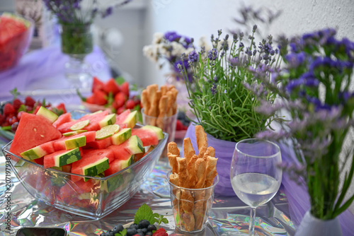 Bild auf Leinwand Watermelon slices and snacks served on a decorated table with lavender flowers