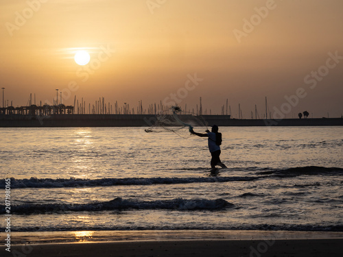 Fishermen on Pinedo beach (Valencia, Spain) at dawn