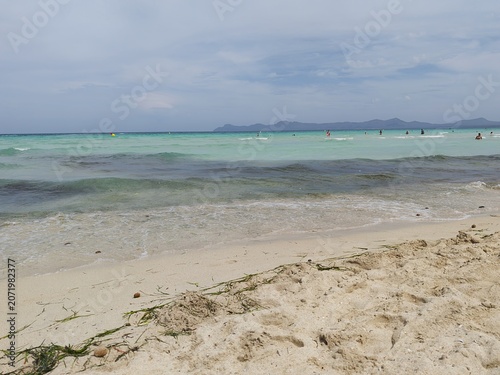 Empty turquoise bay of Muro, Mallorca under cloudy sky, Mediterranean seascape