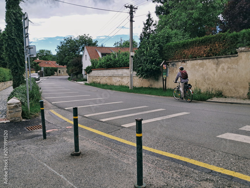 A cyclist riding down Rovinska street on the ev4 cycle route between Hlasna Treban and Karlstejn in the Czech Republic.