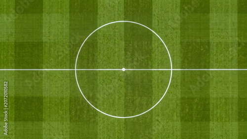 Overhead view of the striped green grass soccer field showing the white center circle and midfield line.