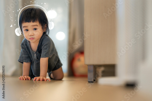 Curious Toddler Crawling Indoors While Imagining Music with Cute Headphone Doodles.