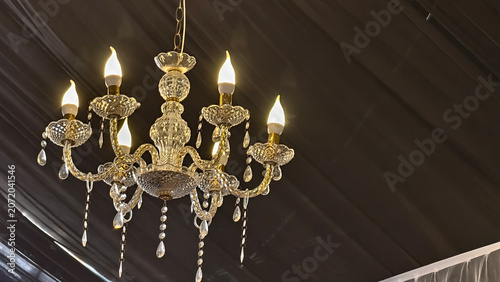 Photos Elegant Crystal Chandelier with Glowing Lights Hanging from Dark Ceiling