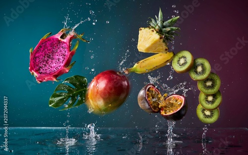 Fresh exotic fruits falling and flying in water splash against dark backdrop
