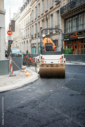 Road roller compacting fresh asphalt on Paris street