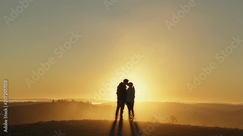 Silhouetted Romantic Couple Kissing on Hilltop Illustrating Love, Connection, and Hope During Golden Hour Sunset.