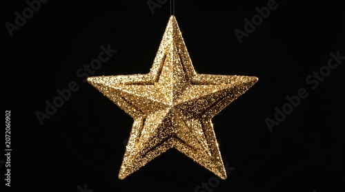 Glittering Golden Star Ornament Isolated on Black Background