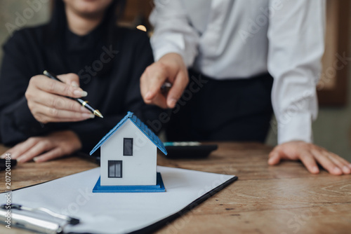 Businessman, house and condo sales representative Hand over the keys to the customer and sign the sales or rental contract according to mutual agreement in the office. Real estate business concept