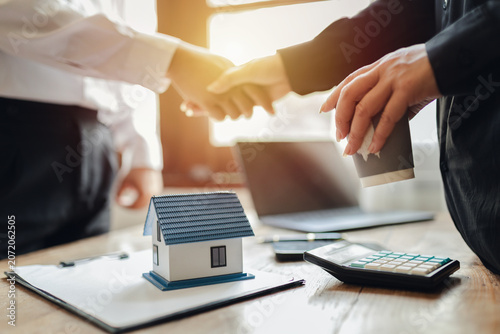 Businessman, house and condo sales representative Hand over the keys to the customer and sign the sales or rental contract according to mutual agreement in the office. Real estate business concept