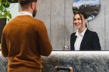 Hotel receptionist assisting guest with check in service