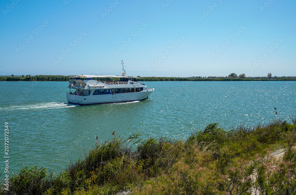 Obraz premium Tourist boat cruising ebro delta river on sunny day