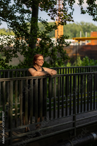 Canvastavla Woman with glasses contemplating on bridge railing in nature