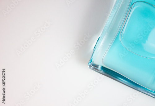 Blue perfume in a glass bottle on a white background. Authentic perfume bottle with copy space.