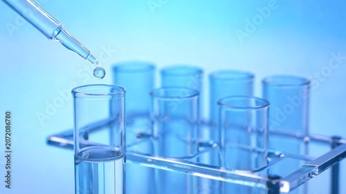 Glass test tube with liquid and dropper in laboratory setting
