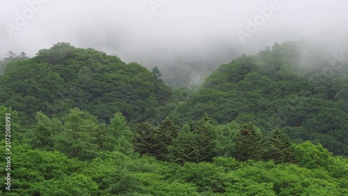 曇天の雲が流れる山の景色