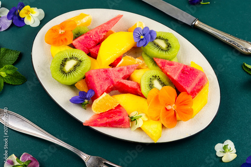 Healthy Tropical Fruit Bowl with Mango, Kiwi and Decorative Edible Flowers
