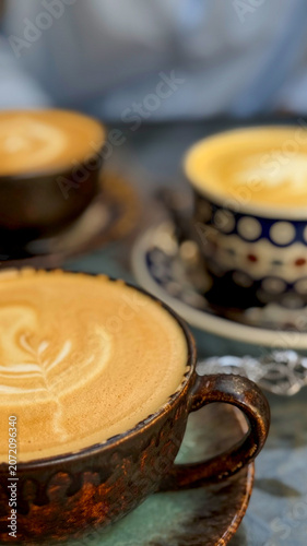 Close-up of coffee cups on a small table at a cozy outdoor café terrace