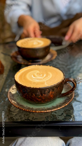 Close-up of coffee cups on a small table at a cozy outdoor café terrace