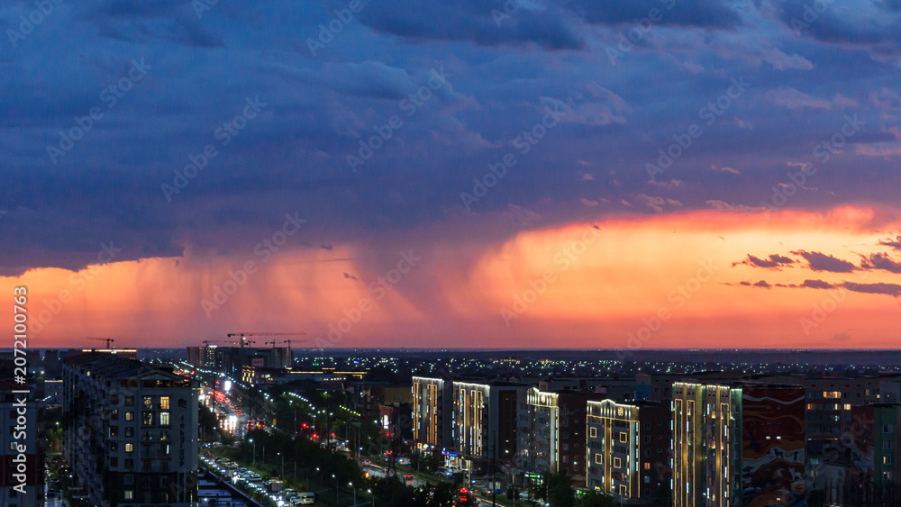 Fototapeta premium Urban skyline at dusk with dramatic clouds and sunset colors illuminating buildings and streets in a modern cityscape, showcasing a vibrant evening atmosphere