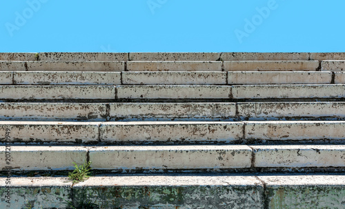 Old concrete staircase against the blue sky.