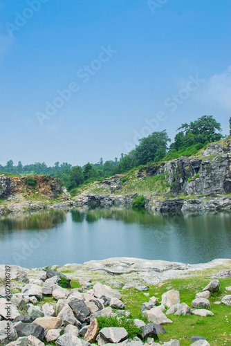 Rocks and stones of Tarpania Lake, Marble Lake, Blue Dam, Patal Dam or Durga Bera,a scenic lake in the Ajodhya Hills of Purulia, West Bengal, India. Blue water surrounded by marble-like rocky cliffs.
