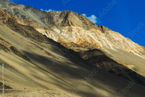 Shadow of low hanging clouds over Himalayas , rocky mountains of Ladakh, , Himalayan mountains in the background, Leh, Jammu and Kashmir, India. Scenic beauty of Ladakh attracts tourists worldwide.