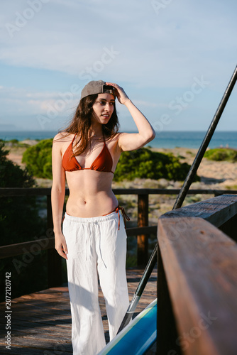 Woman preparing for paddle board activity at beach