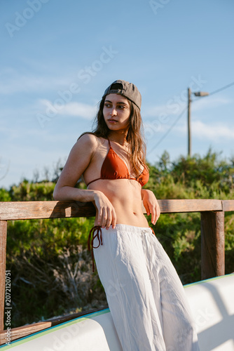 Woman posing in bikini top and cap enjoying summer