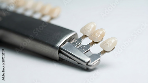  Close up of dental tooth shade samples for professional color matching and shade selection in aesthetic dentistry and porcelain restoration treatments in dental clinic on white background.
