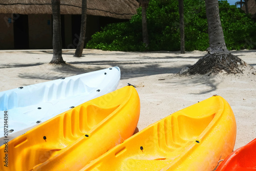 Colorful kayaks on a sandy beach.