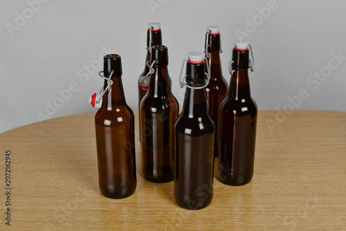 Grupo de botellas de cervezas artesanal con cierre hermético sobre mesa de madera
