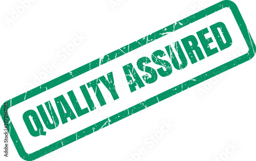 Green ink rubber stamp mark with the text quality assured isolated on a plain surface