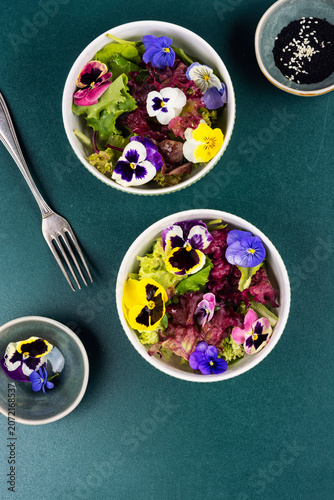 Fresh Green Leaf Salad with Colorful Edible Flowers in Ceramic Bowl