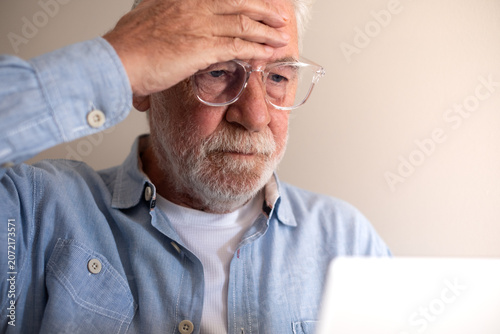 Cuadro en lienzo Senior man experiencing stress and frustration while looking at a laptop, feelin