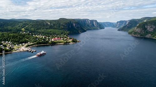 Aerial view of a ferry cruising through a scenic fjord valley