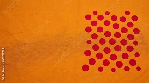 Vibrant orange fabric with red polka dots and subtle texture
