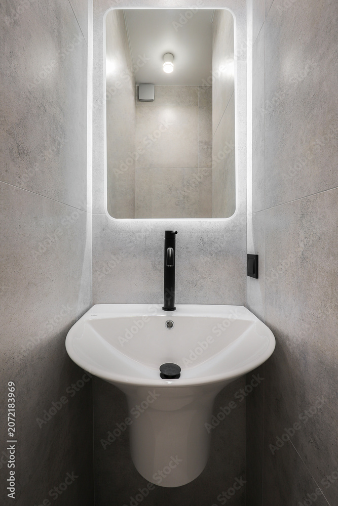 Fototapeta premium Faucet with ceramic sink with mirror in the bathroom