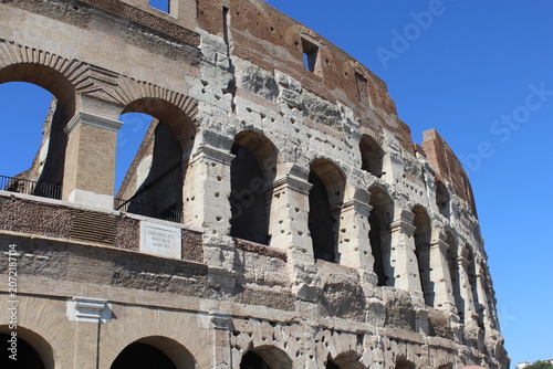 ROME, ITALY - JUNE 5, 2016: Low angle close-up of the Colosseum facade against a blue sky